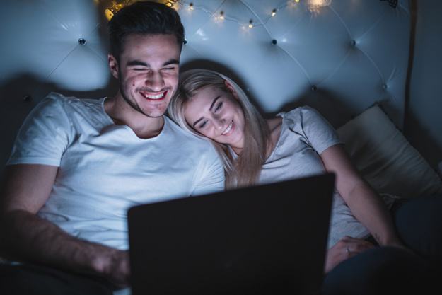 smiling couple watching film bed 23 2147771152