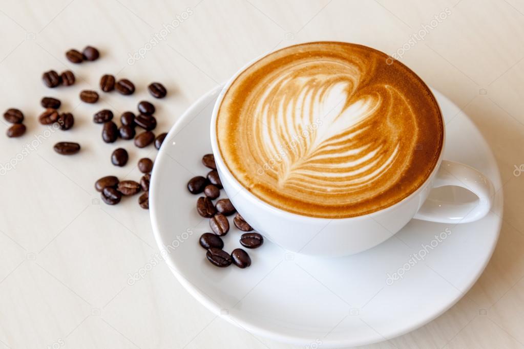 Hot cafe latte and coffee beans Stock Photo by ©yktr 78249960